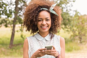 Happy young woman using smartphone on a sunny day